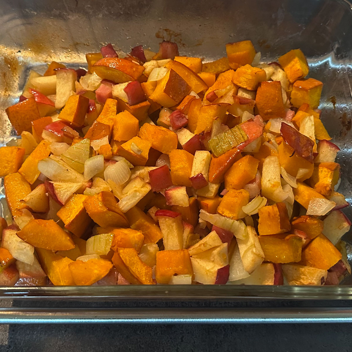 Ovenschaal met de pompoen, appel, uien, peper en knoflook